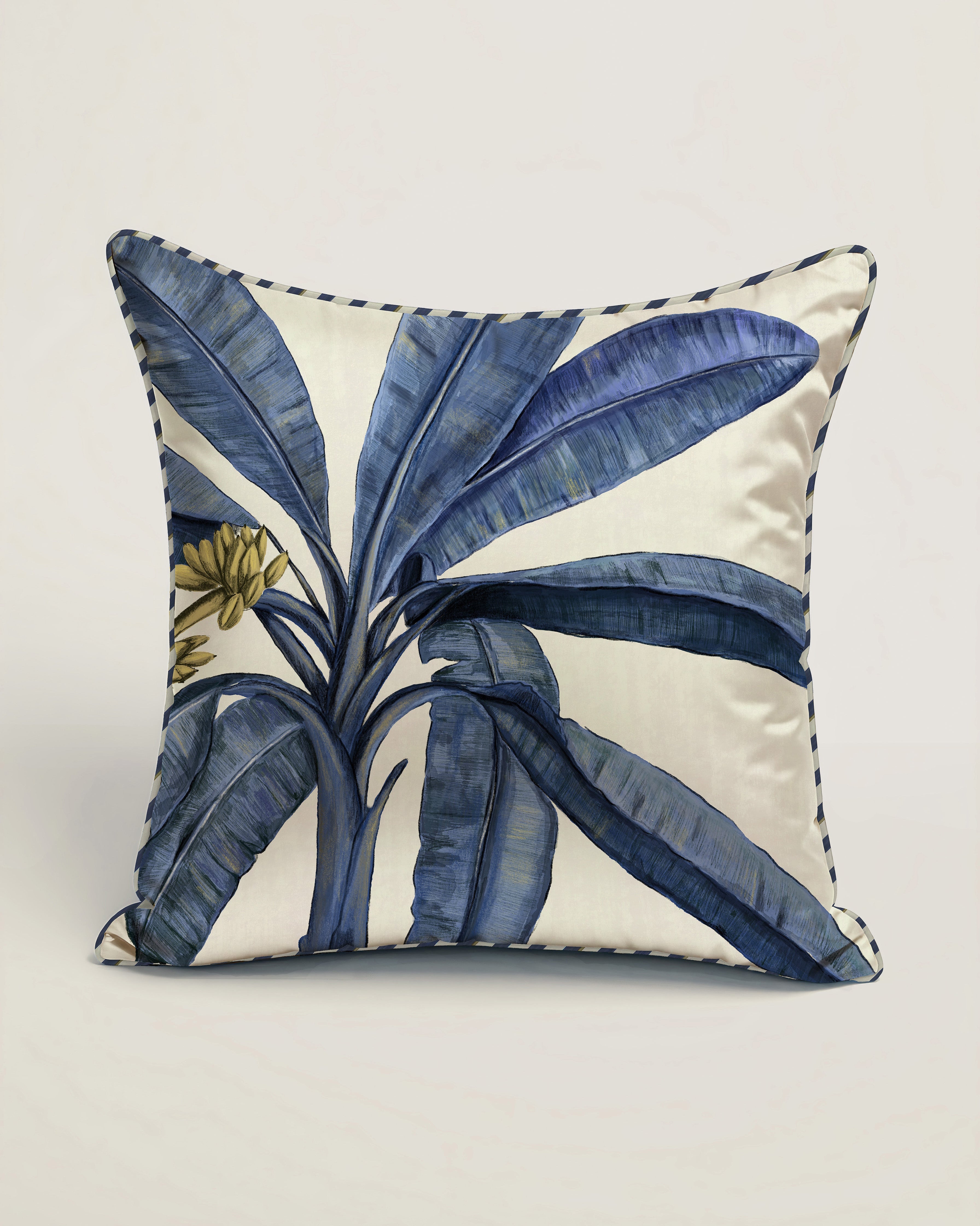 Decorative pillow with blue leaf pattern on a white background