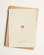 Card with a red heart and text on a beige background