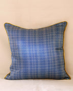 Blue patterned pillow with yellow trim on a beige background