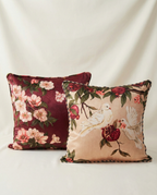 Two decorative pillows with floral and Duo dove illustration on a plain background