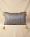 Navy striped pillow with yellow tassels on a beige background