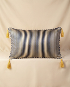Navy striped pillow with yellow tassels on a beige background