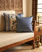 Wooden sofa with patterned cushions in a room with decorative elements.