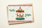 Christmas card with reindeer and striped envelope on a beige background