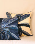 Two decorative pillows with leaf patterns on a beige background
