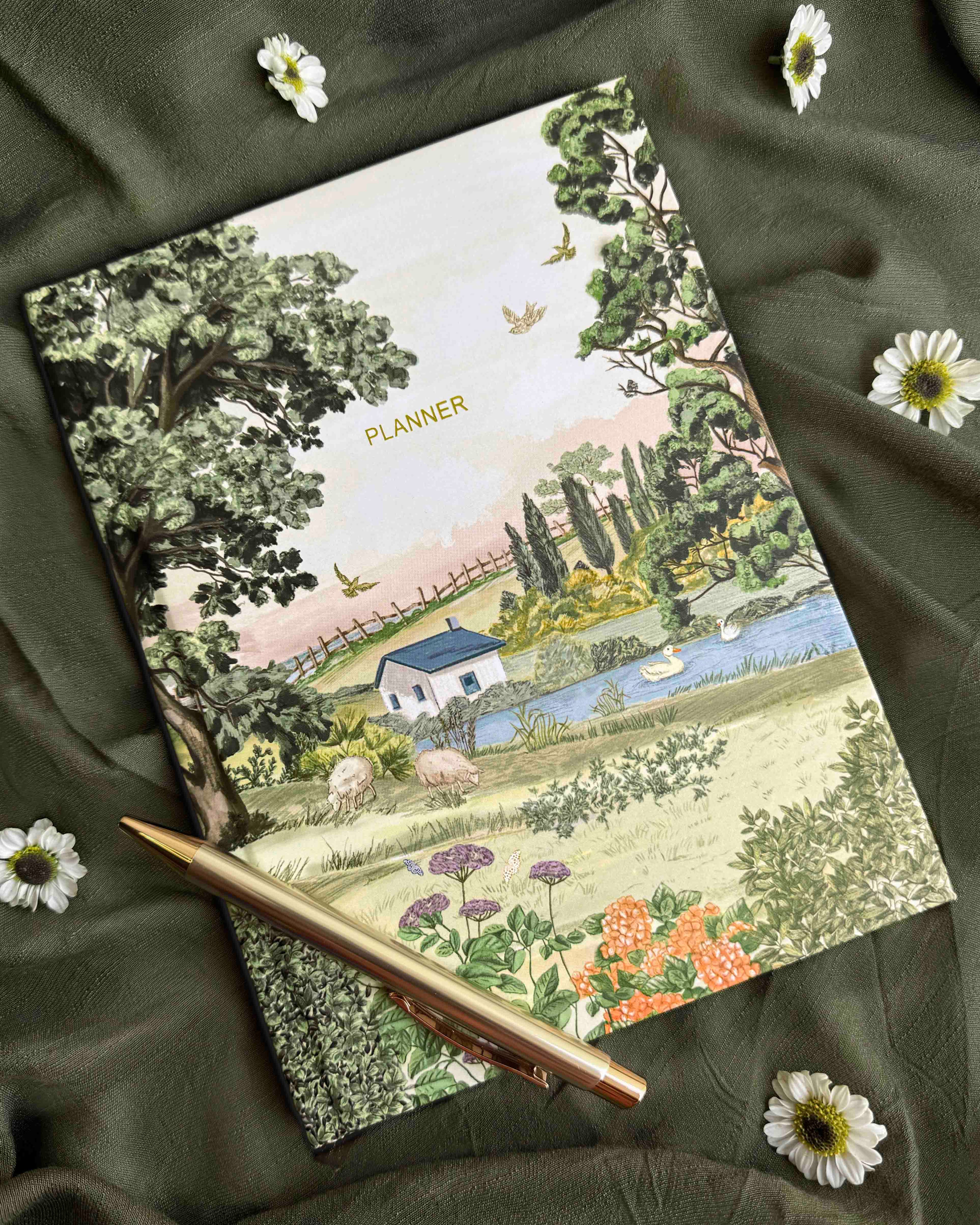 Planner with nature-themed cover on a green fabric background