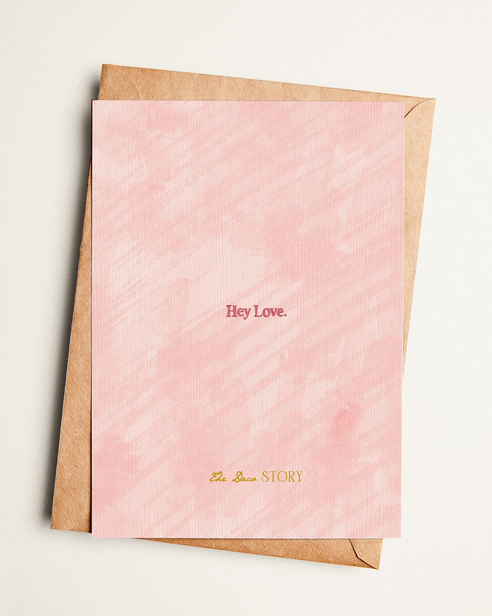 Pink card with gold text on a beige background