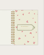 Spiral-bound notebook with decorative cover on a light gray background