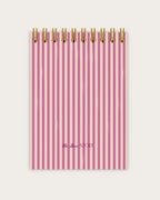 Pink striped notebook with gold wire binding on a white background