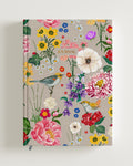 A5-sized journal with a beige background & floral design cover featuring various flowers and a bird. Ideal for festive gifting and stationery lovers