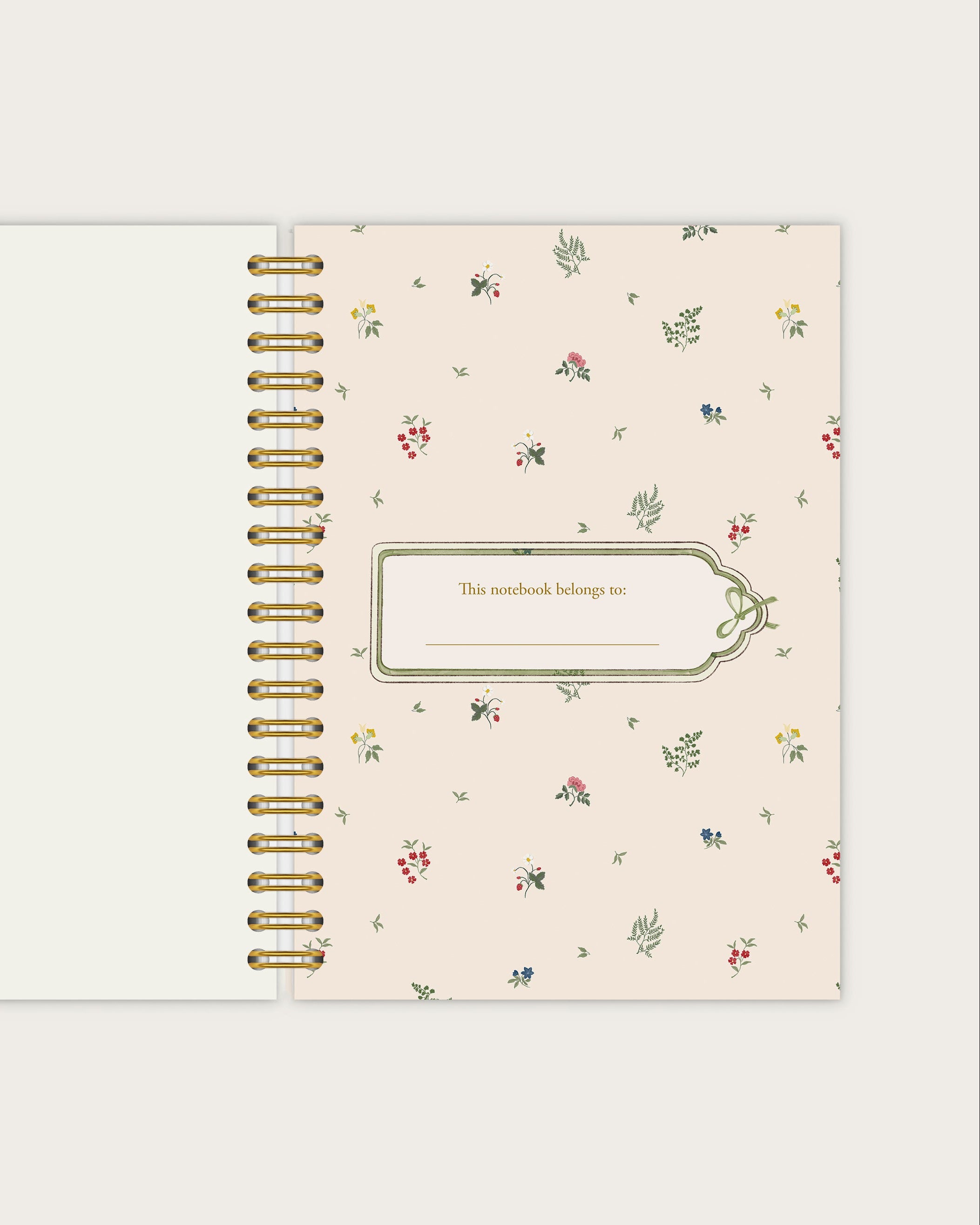 Floral patterned notebook with gold spiral binding on a white background