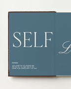 Open planner with 'SELF LOVE' on a blue background