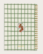 Notebook back with green grid pattern and cherry illustration on a off white background